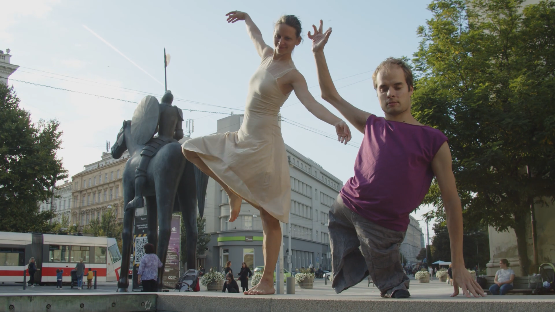Tanečnice a tanečník pózující na kašně za sochou markraběte Jošta v Brně